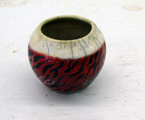 Raku with Red Glaze, Artwork by Madeleine Baker currently showing at The Water's Edge Studio and Gallery, Artwork is titled 'Embers', Raku with Red Glaze, about 4 inches high; Contact thewatersedge at houston dot rr dot com for more information
